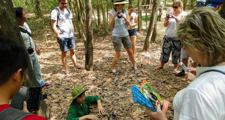 Una persona saliendo de un túnel subterráneo rodeada de turistas con cámaras.