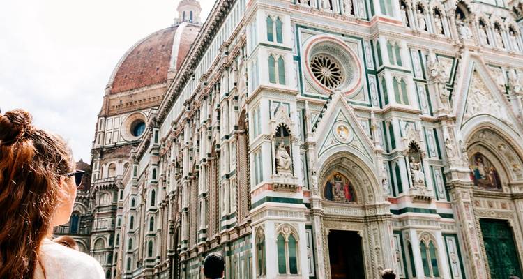 Vue d'une cathédrale aux décorations complexes avec un dôme dans un cadre urbain.