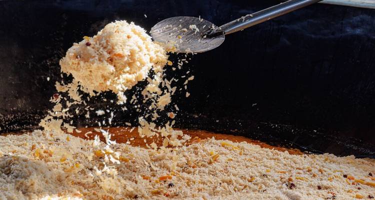 Grande marmite de riz remuée avec une louche.