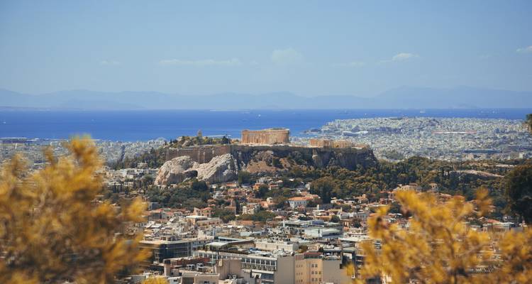Vue panoramique lointaine d'Athènes avec la colline de l'Acropole se dressant au-dessus de la ville et la mer Égée en arrière-plan