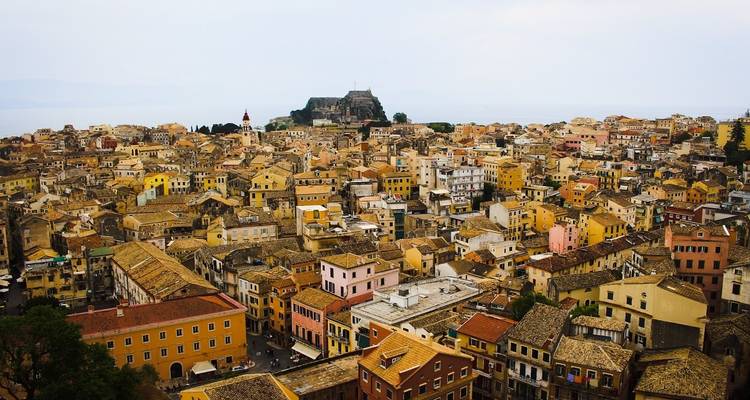 Vue panoramique sur une dense vieille ville méditerranéenne aux toits d'ocre avec une forteresse perchée sur une colline et la mer au-delà