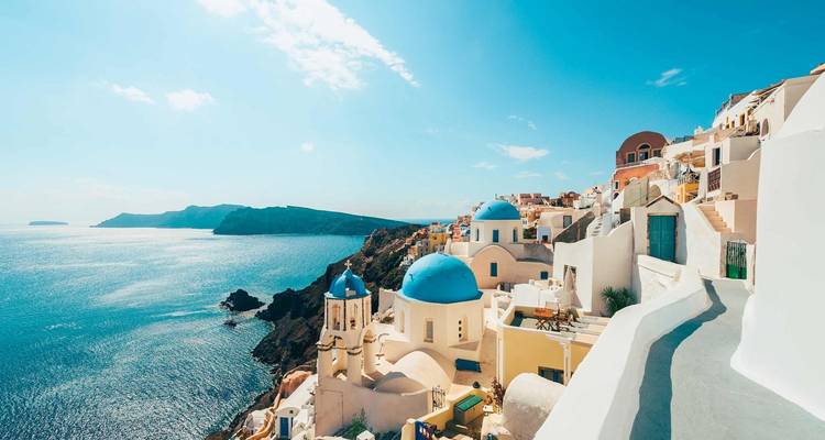 Classic view of Santorini with blue domed churches and sea.