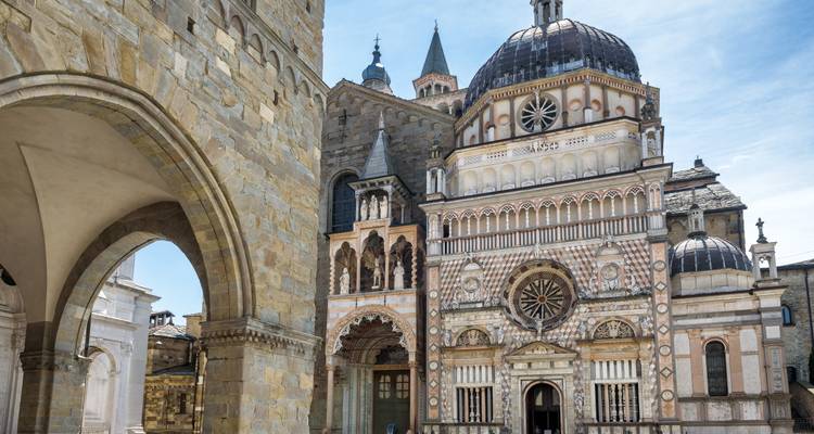 Nahaufnahme der kunstvollen Colleoni-Kapelle von Bergamo und der angrenzenden Basilika mit komplizierter Marmorfassade und Rosenfenster.