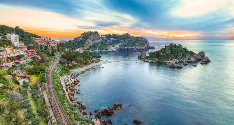 Scenic coastal view with mountains and railway track.