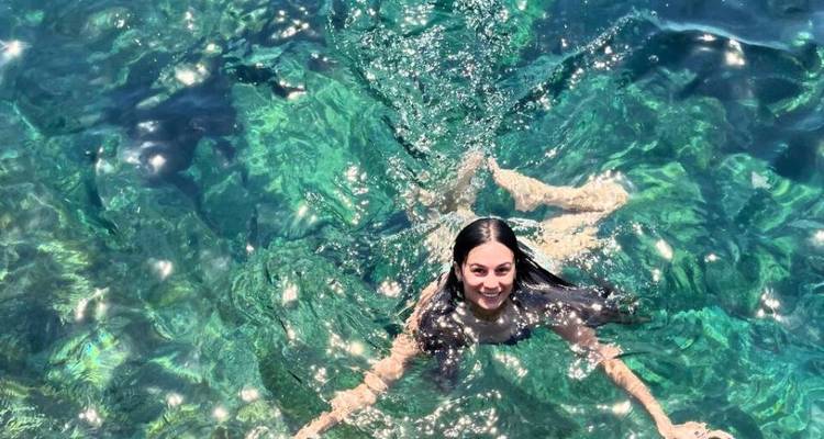 Woman swimming in clear turquoise water.