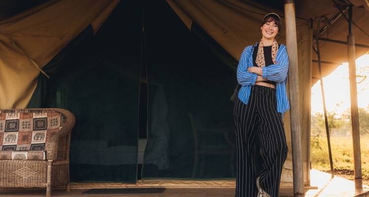 Mujer sonriendo en la entrada de una tienda de safari.