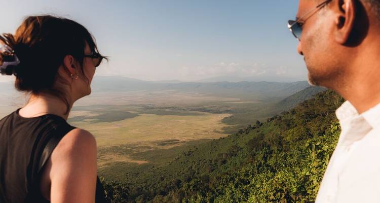 Two people overlooking a vast valley landscape.