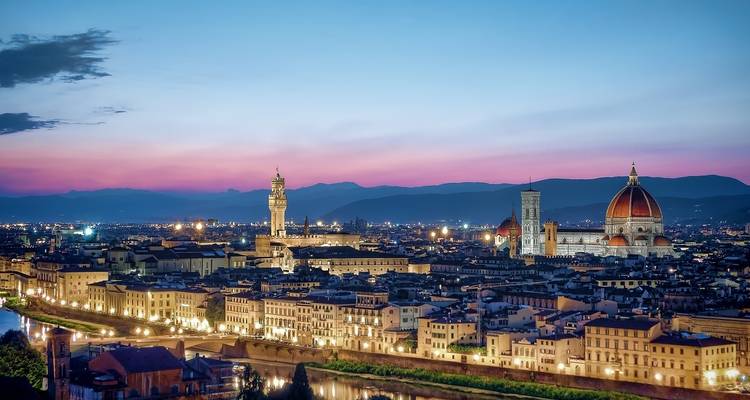 Panoramic view of Florence at dusk, with prominent cathedrals.