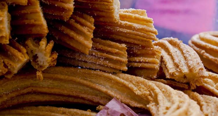 Gros plan de churros empilés dans une vitrine.