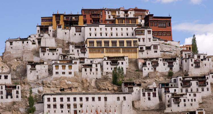 Tiered white-washed buildings of Thiksey Monastery stacked on a rocky Ladakh hillside