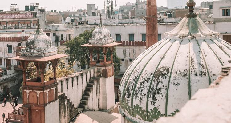 Rustic city rooftops with domed structures and urban background.