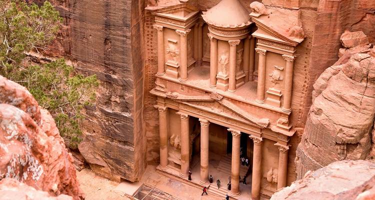 Das ikonische Schatzhaus von Petra, in den Fels gehauen, mit Touristen darunter.
