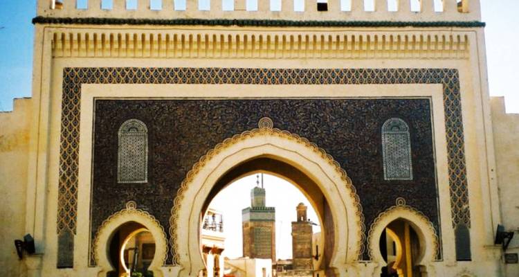 Sierlijke poort met ingewikkelde tegels en een boog.