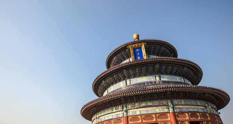 Upward close-up of the ornate roof tiers of the Temple of Heaven against a clear blue sky.