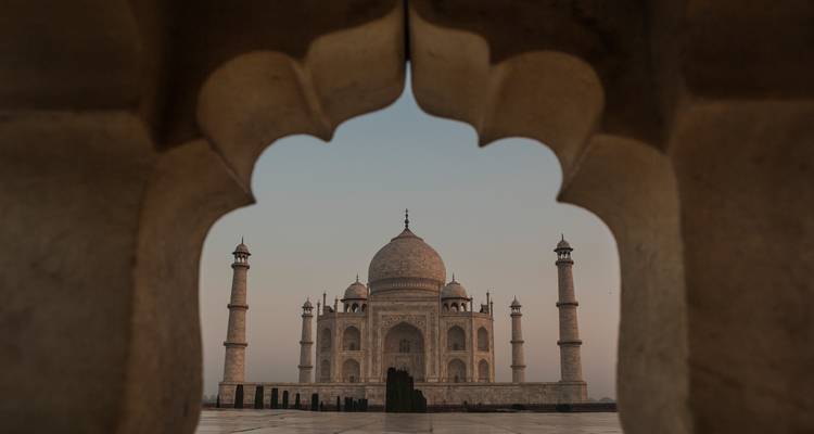 Zicht op de Taj Mahal omlijst door een sierlijke boog.