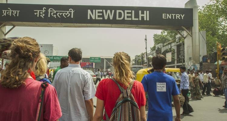 Een groep toeristen die New Delhi binnenkomt onder een straatnaambord.