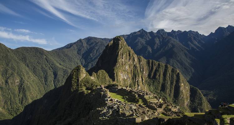 Machu Picchu enclavado en la cordillera de los Andes bajo un cielo parcialmente nublado.
