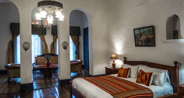 Elegante habitación de hotel con decoración tradicional y araña de luces.
