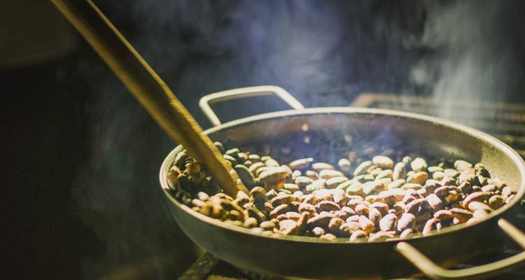 Nahaufnahme von Kakaobohnen, die in einer Pfanne geröstet werden.