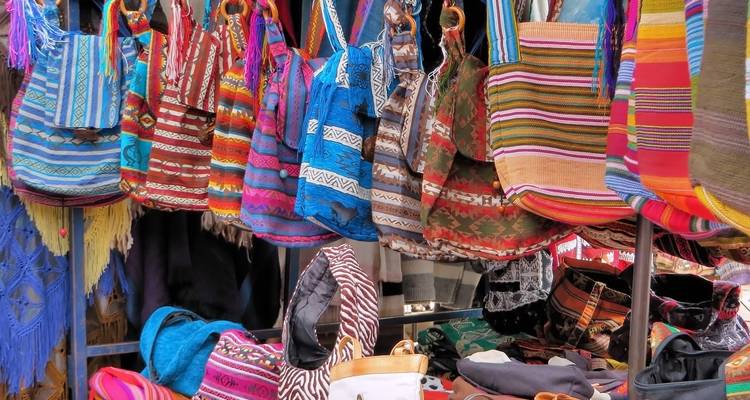 Bunte gewebte Taschen, die in einem Marktstand hängen.