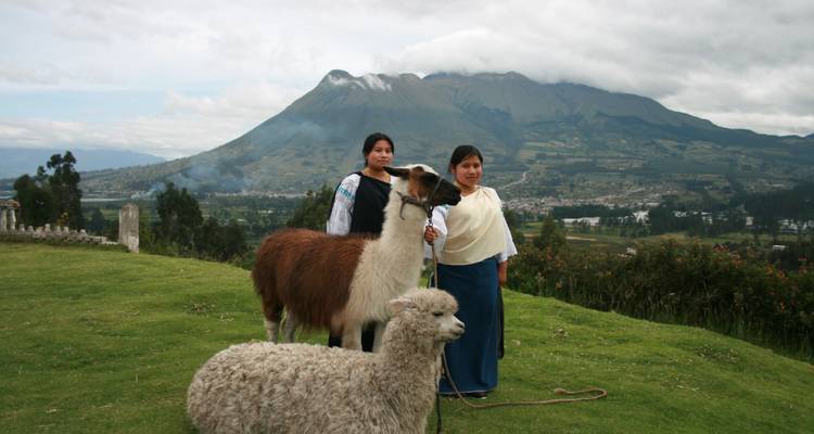 Frauen posieren mit Lamas in den Bergen.