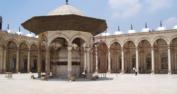 Une cour avec une structure à dôme entourée de colonnes architecturales.