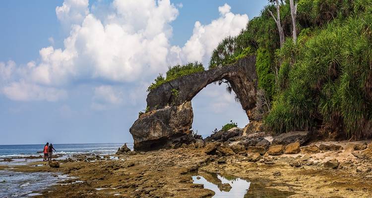 A natural stone arch formation on a rocky coast.
