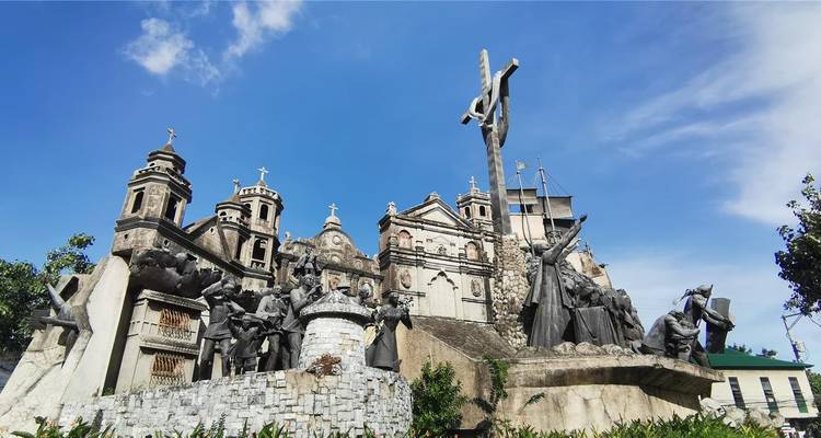 Dramatic heritage monument depicting historical religious figures against a vivid blue sky.