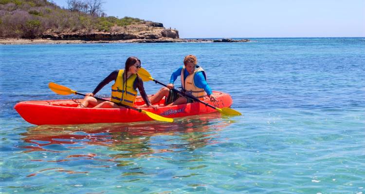 Twee mensen die kajakken op een heldere blauwe zee.