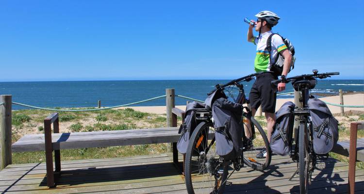 Personne buvant de l'eau à côté de vélos avec vue sur la mer