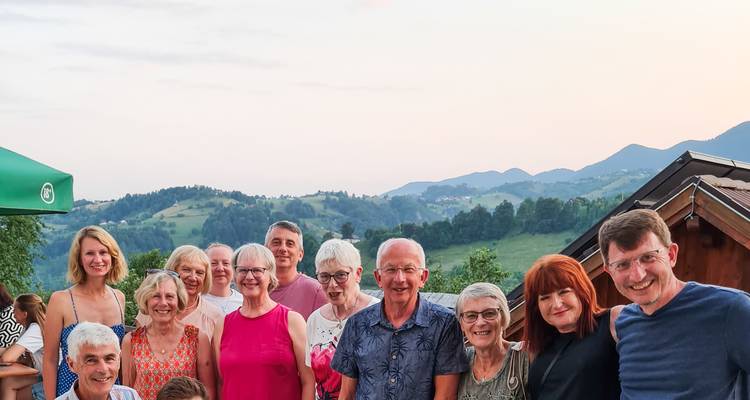 Gruppenporträt am Abend mit lächelnden Reisenden vor einer Kulisse von sanften rumänischen Hügeln in der Dämmerung.