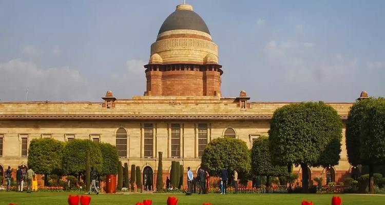 Regeringsgebouw met koepel and prachtig onderhouden tuin.