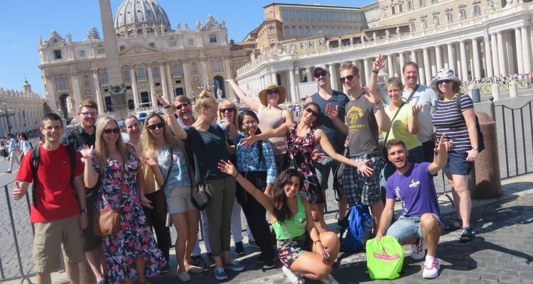 Grote groep poseert voor de Sint-Pietersbasiliek in Vaticaanstad.