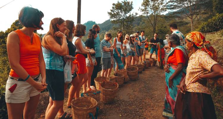 Des touristes interagissant avec des habitants le long d'un sentier rural.