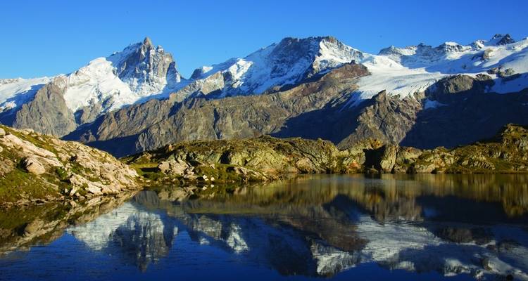 Majestic mountain range reflected in a calm lake.