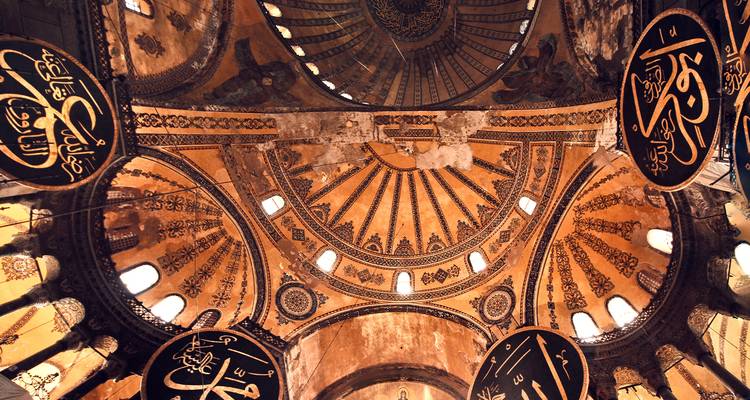 Plafond intérieur orné d'un bâtiment historique avec calligraphie islamique.