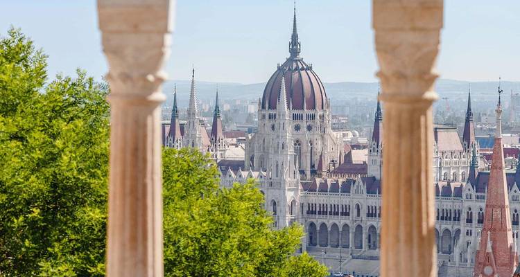 Le bâtiment du Parlement hongrois de Budapest vu à travers les colonnes ornées du Bastion des Pêcheurs.