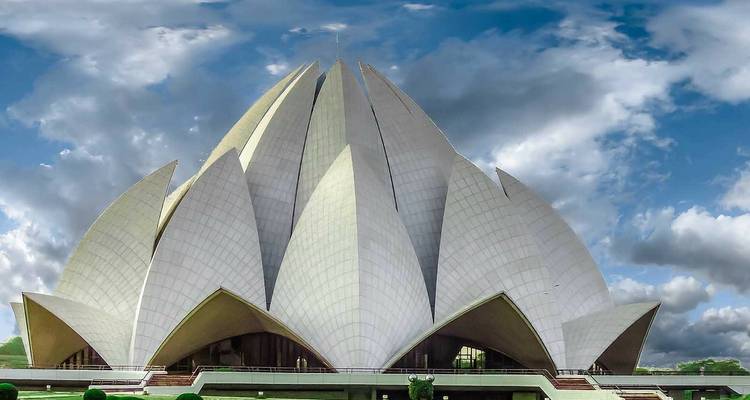 Markanter weißer blütenblattförmiger Tempel, der unter dramatischen Wolken aufsteigt
