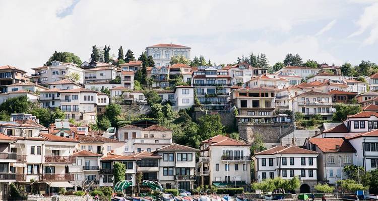 Paysage urbain avec des maisons à flanc de colline aux toits rouges.