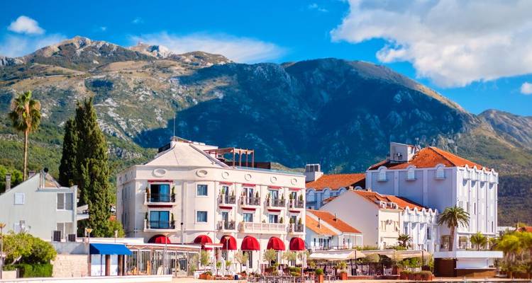 Ville côtière pittoresque avec des montagnes en arrière-plan.