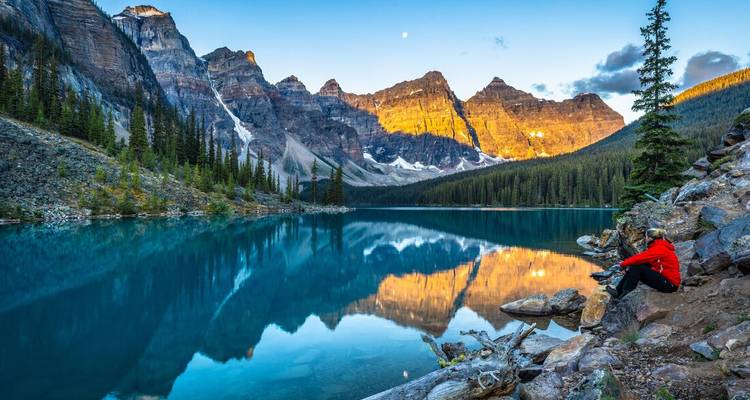 Personne profitant de la vue sur un lac entouré de montagnes.