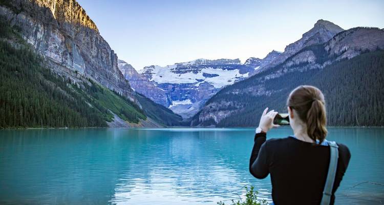Personne prenant une photo d'une montagne et d'un lac pittoresques.