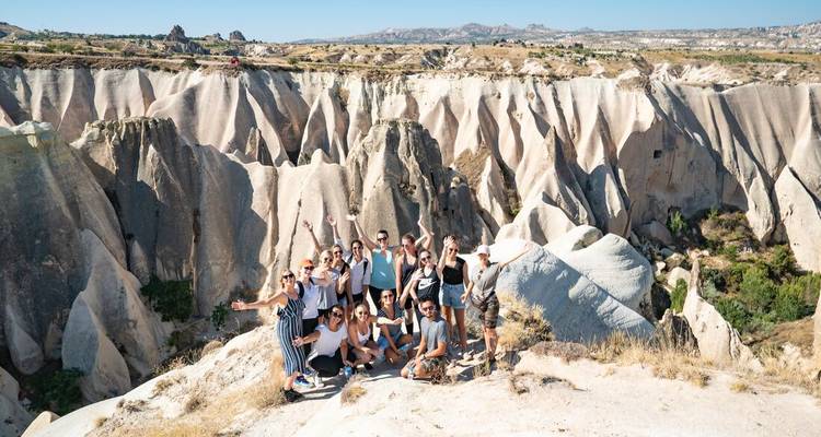 Groupe de personnes posant sur un paysage pittoresque avec des formations rocheuses uniques.