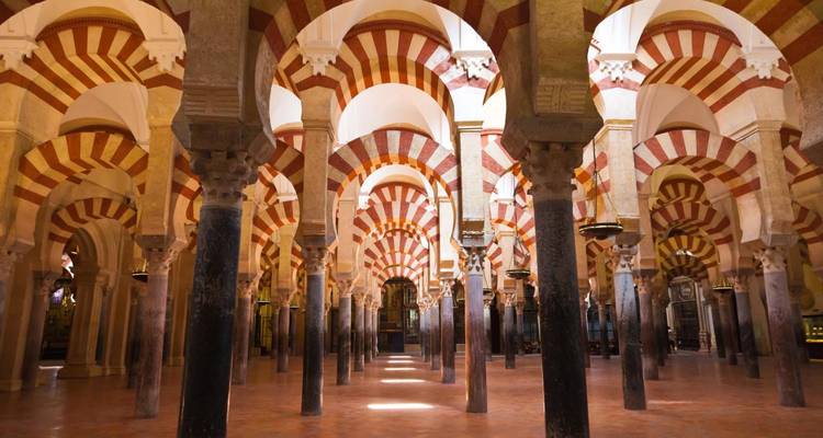 Interieur van een historisch gebouw met bogen en zuilen.