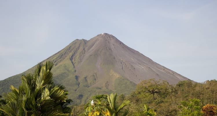 Vue d'un volcan proéminent avec une végétation luxuriante autour.