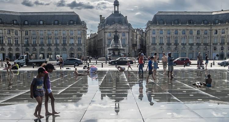Fuente de agua en una plaza pública con edificios históricos.