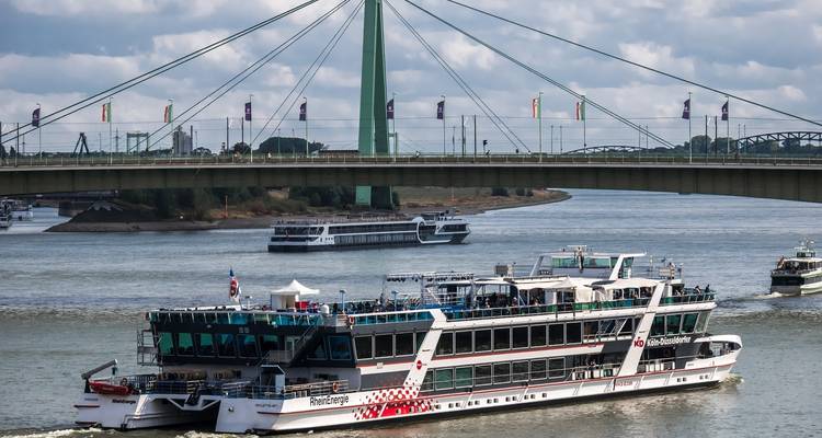 Un río con barcos bajo un puente en un día nublado.
