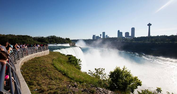 Chutes du Niagara avec brume et horizon urbain en arrière-plan.