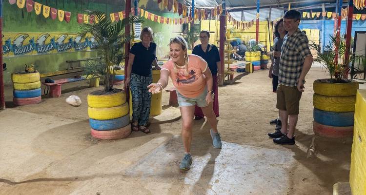 Grupo de personas jugando un juego en interiores con neumáticos coloridos en el fondo.