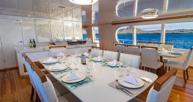 Ein eleganter Essbereich auf einer Yacht mit Blick auf das Meer durch die Fenster.